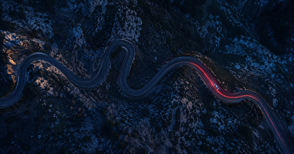 GPS satellite view from directly above a winding mountain road at dusk